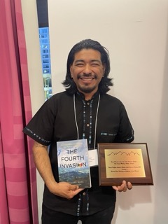 Batz holding his book and award